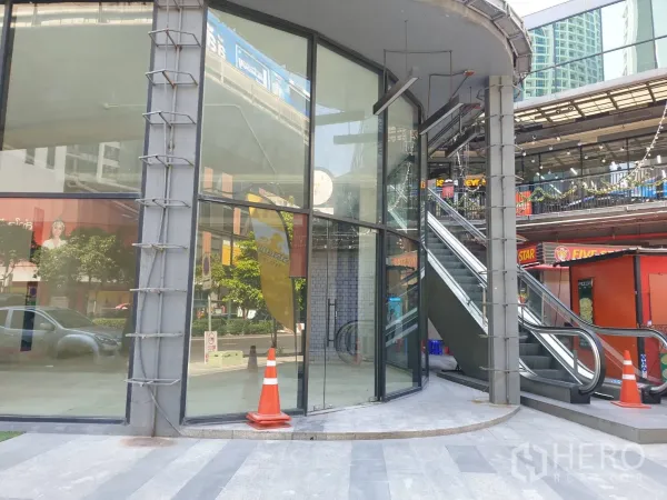 พื้นที่ขายปลีก ให้เช่าในWatthana, Bangkok - หน้าร้านมุมอาคาร กระจกโค้งเต็มความสูง ข้างบันไดเลื่อนภายนอกในคอมมูนิตี้มอลล์