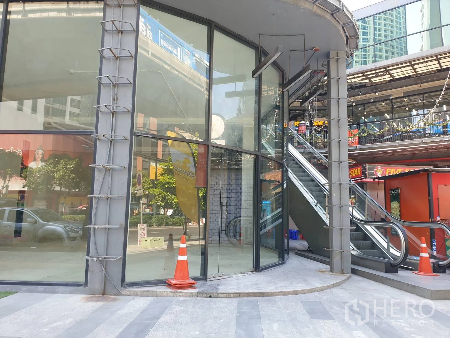 พื้นที่ขายปลีก ให้เช่าในWatthana, Bangkok - หน้าร้านมุมอาคาร กระจกโค้งเต็มความสูง ข้างบันไดเลื่อนภายนอกในคอมมูนิตี้มอลล์