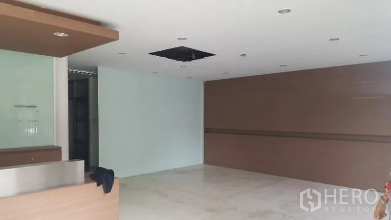 货栈 出租在Suan Luang, Bangkok - 一层接待区，内置前台、吊顶筒灯与玻璃装饰墙。