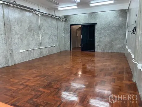 办公空间 出租在Yan Nawa, Bangkok - 宽敞办公室，拼花木地板，清水混凝土墙，黑框推拉门与顶灯。