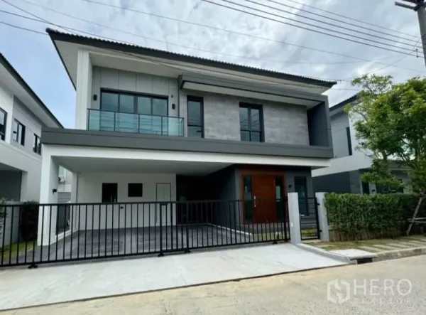 独立式住宅 出租在Bang Phli, Samut Prakan - 现代两层独栋别墅外观，带入户电动门和二楼阳台。