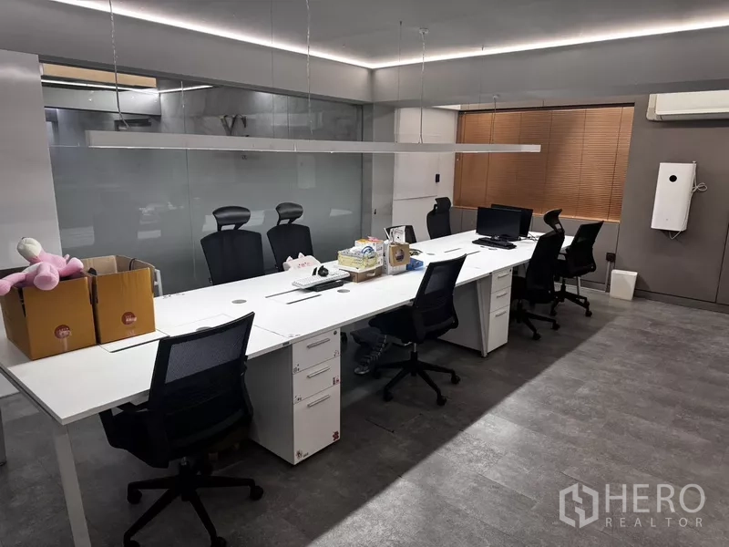 Office Space for rent or sale in Suan Luang, Bangkok - Open-plan office with long white workstation, task chairs and suspended linear lighting.