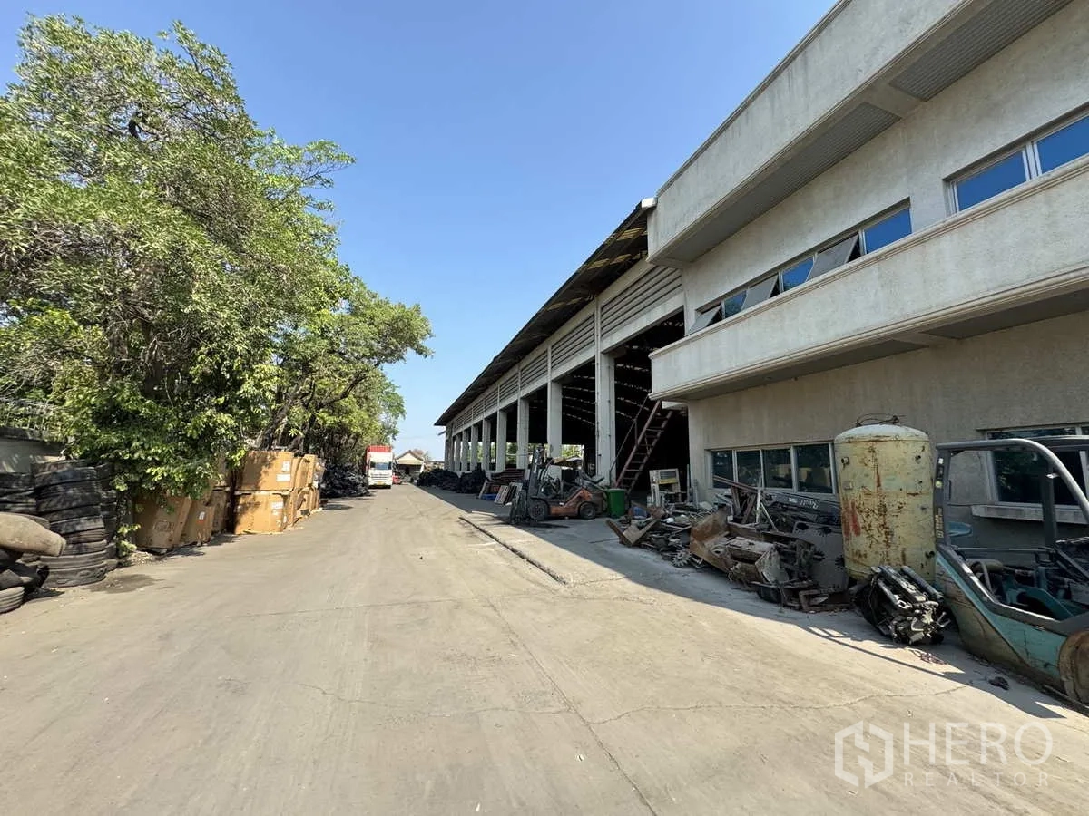 โรงงาน ให้เช่าในLat Lum Kaeo, Pathum Thani - ถนนด้านข้างติดอาคารคลังสินค้าพร้อมต้นไม้และวัสดุเก็บกอง