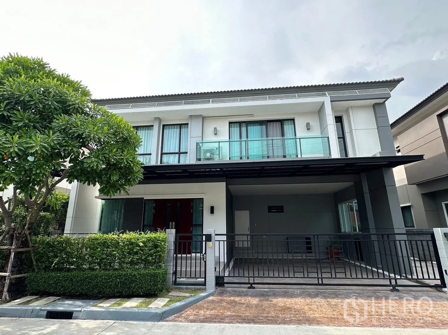 Detached House for rent in Bang Phli, Samut Prakan - Modern two-storey detached house exterior with balcony, carport and front gate.
