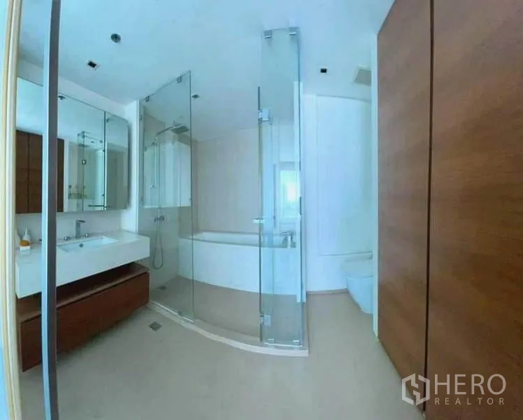 Condominium for rent in Khlong San, Bangkok - Spacious bathroom featuring a glass shower, soaking tub, vanity and toilet.