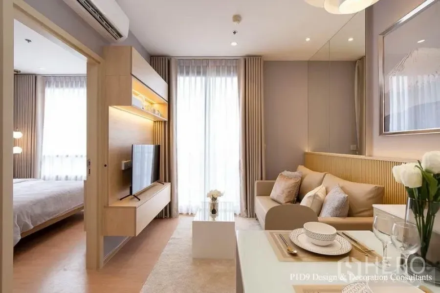 公寓 出租在Watthana, Bangkok - 客厅电视柜与置物架，推拉门通卧室，落地窗通向阳台。