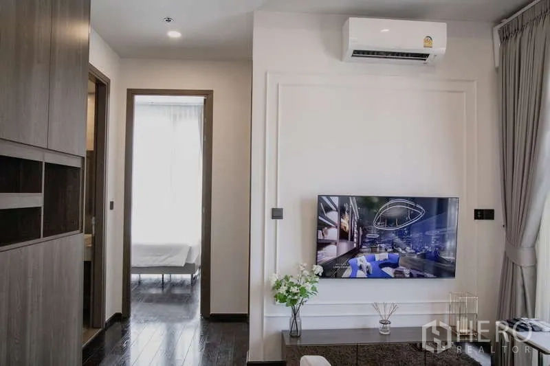 คอนโด ให้เช่าในWatthana, Bangkok - ผนังทีวีในห้องรับแขก พร้อมเครื่องปรับอากาศ และทางเข้าห้องนอนในคอนโดสวย