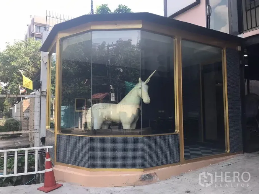 Retail Space for rent in Watthana, Bangkok - Corner retail shopfront with floor-to-ceiling glass windows and gold trim.