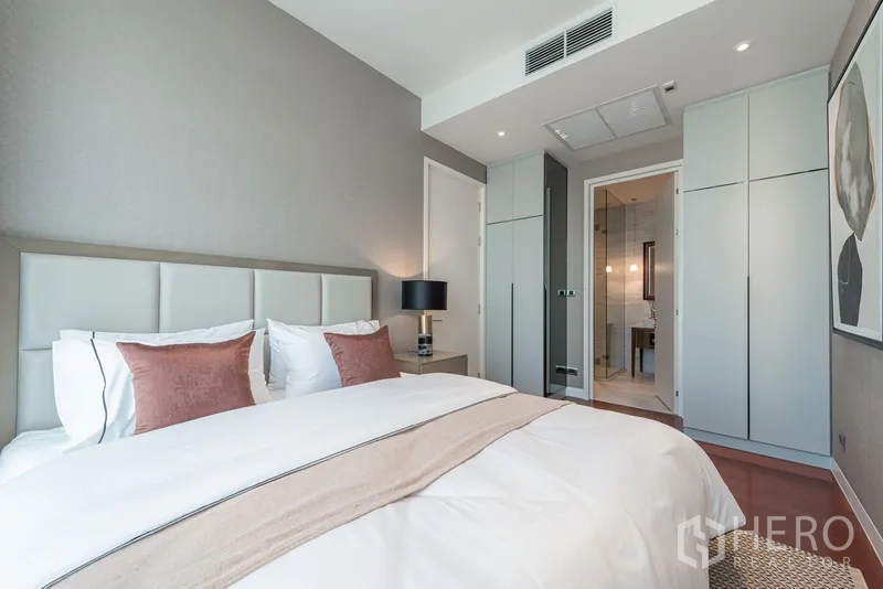 公寓 出售在Watthana, Bangkok - 卧室视角可见内置衣柜与通往现代卫浴的门。