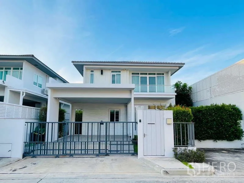 Detached House for rent in Prawet, Bangkok - Front facade of a contemporary detached home with driveway and secure gate.
