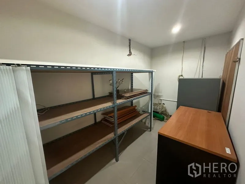 Office Space for sale - Storage room with metal shelving units and tiled flooring.