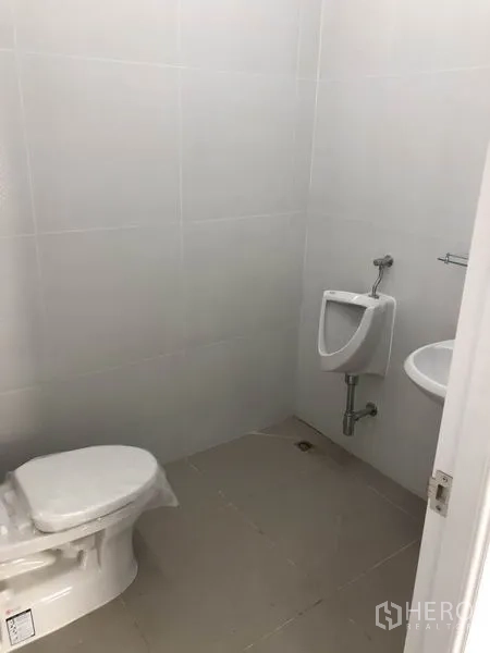 Factory for rent in Phra Nakhon Si Ayutthaya - Tiled restroom with toilet, urinal and sink inside the facility.