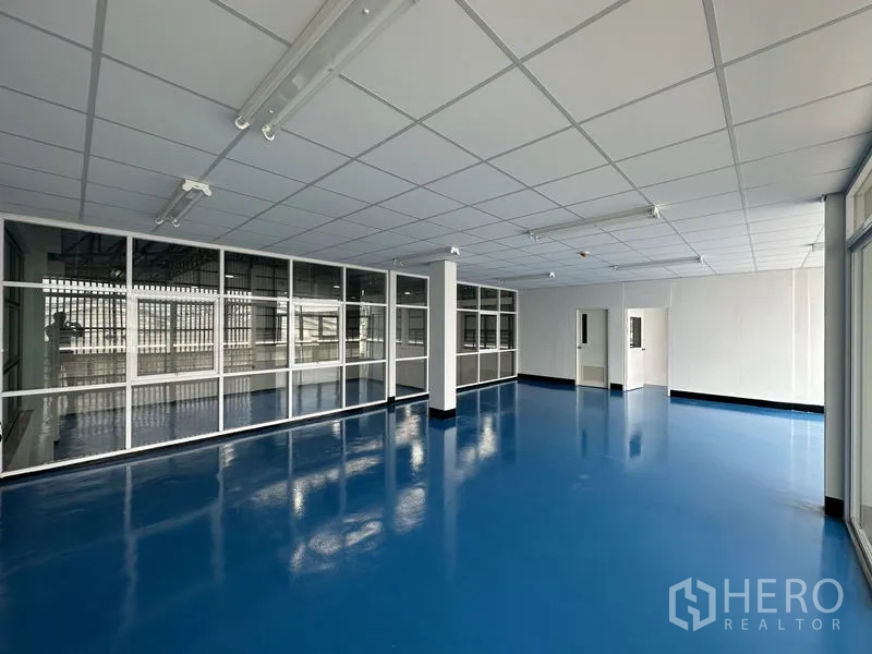 Factory for rent in Khlong Luang, Pathum Thani - Bright office space with floor‑to‑ceiling glass and internal windows facing the production area.