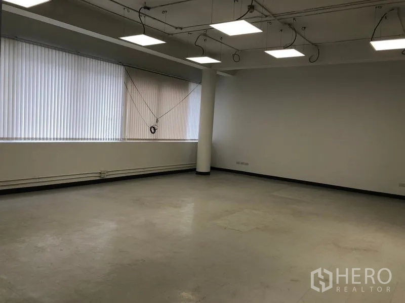 Office Space for rent in Bang Rak, Bangkok - Large flexible room with concrete floor, suspended LED panels and long windows with blinds.