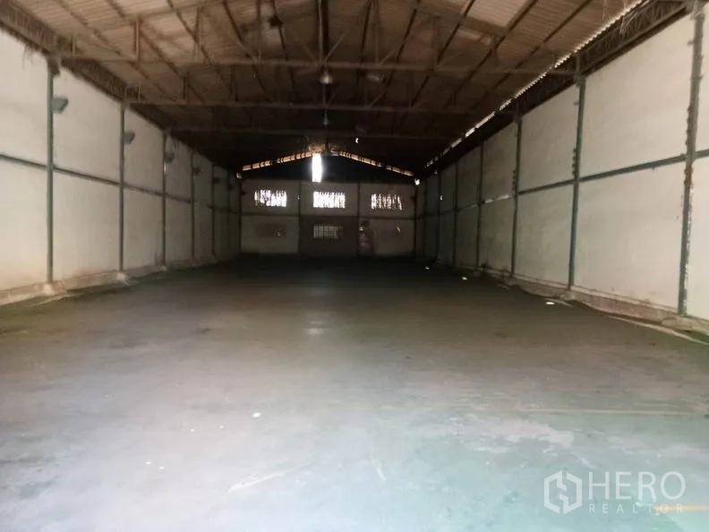 Warehouse for rent in Bang Sao Thong, Samut Prakan - Wide-span warehouse interior with high steel truss roof and smooth concrete floor.