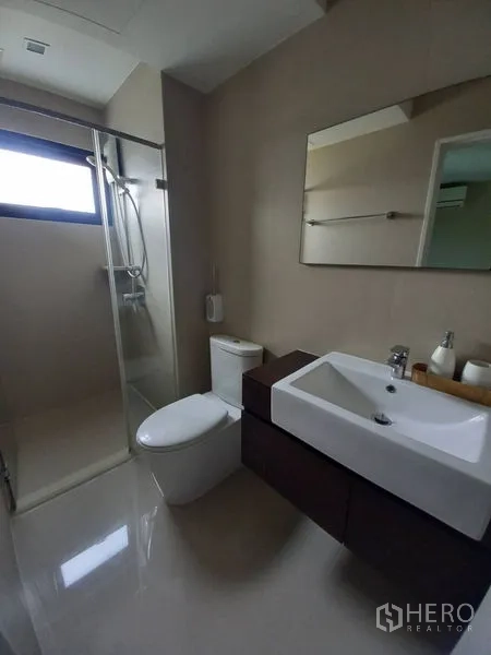 Townhouse for rent in Suan Luang, Bangkok - Modern bathroom with glass shower enclosure, vanity basin and toilet.