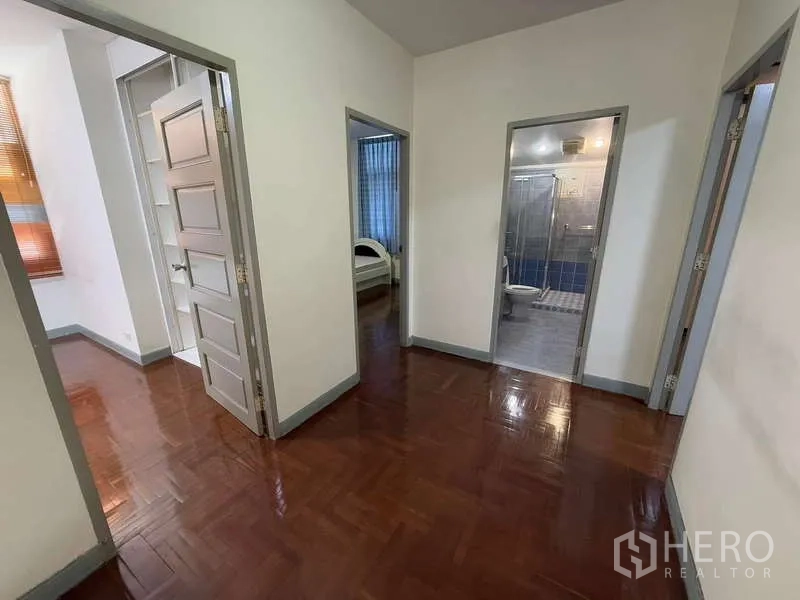 独立式住宅 出租在Bang Kapi, Bangkok - 二层走廊，木地板并通往卧室和浴室的多扇门。