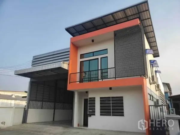 Warehouse for rent in Lam Luk Ka, Pathum Thani - Contemporary warehouse exterior with orange office facade and metal awning.