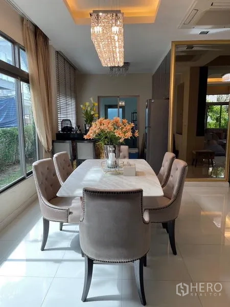 Detached House for sale in Lat Krabang, Bangkok - Dining area with marble table, upholstered chairs and sparkling pendant chandelier.