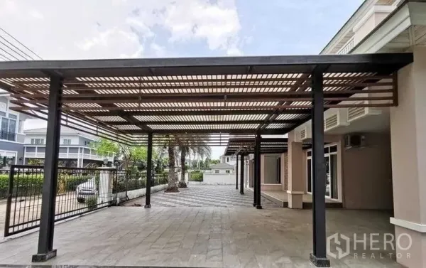独立式住宅 出售在Lat Krabang, Bangkok - 宽阔入户大门与双车位车棚及铺砖前庭。