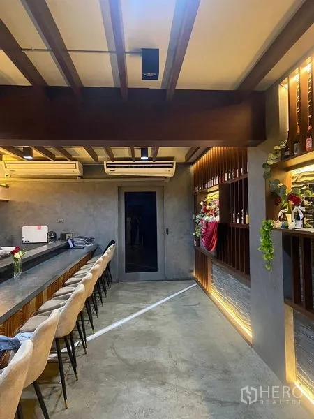 Shophouse for rent - Long bar lounge with concrete counter, exposed beams, and warm mood lighting.