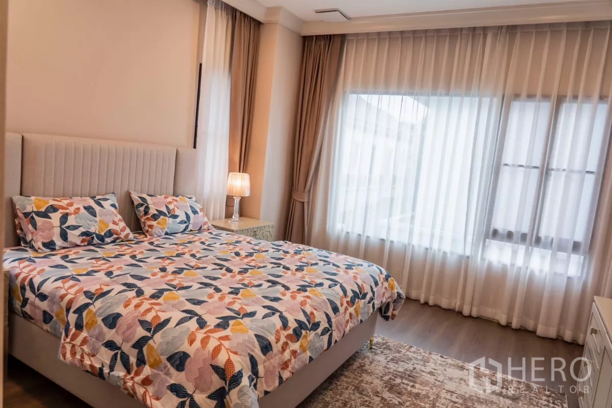 Detached House for rent in Saphan Sung, Bangkok - Bright bedroom with floral bedding and sheer curtains.