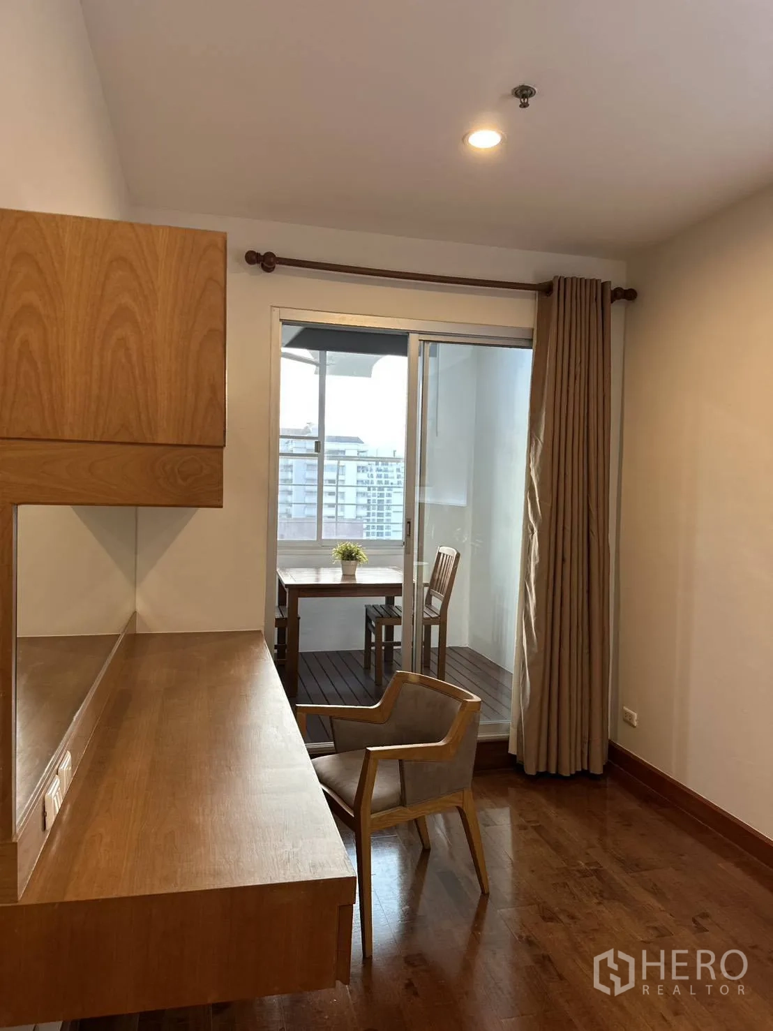 公寓 for rent in Watthana, Bangkok - 带长木质内置书桌与椅子的书房角，连接到带座位的阳台。