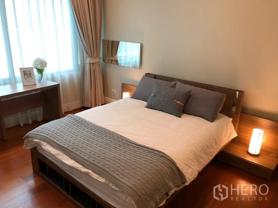 Condominium for rent or sale in Khlong Toei, Bangkok - Bright bedroom with double bed, bedside tables, desk and large curtained windows.