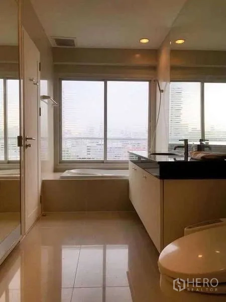 公寓 出租或出售在Watthana, Bangkok - 主卫带浴缸与宽台面，大窗可观城市景色。