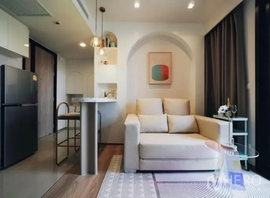 Condominium for rent - Living area with cream sofa, arched shelving and full-height curtains.