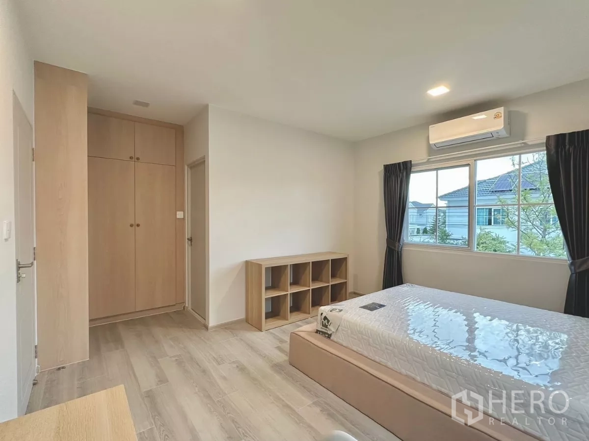 Detached House for rent in Bang Phli, Samut Prakan - Guest bedroom angle with wardrobe, shelving and neutral decor.