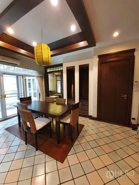 Detached House for rent in Wang Thonglang, Bangkok - Dining area with wooden table for four, pendant light and sliding glass doors to the terrace.