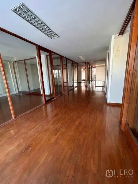 Home Office for rent or sale in Bang Phli, Samut Prakan - Another long corridor showcasing numerous glass rooms and warm wood flooring.