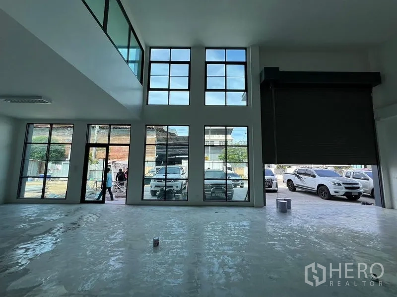 Warehouse for rent in Bang Sao Thong, Samut Prakan - Ground-floor space with tall windows and a wide shutter opening suitable for loading operations.