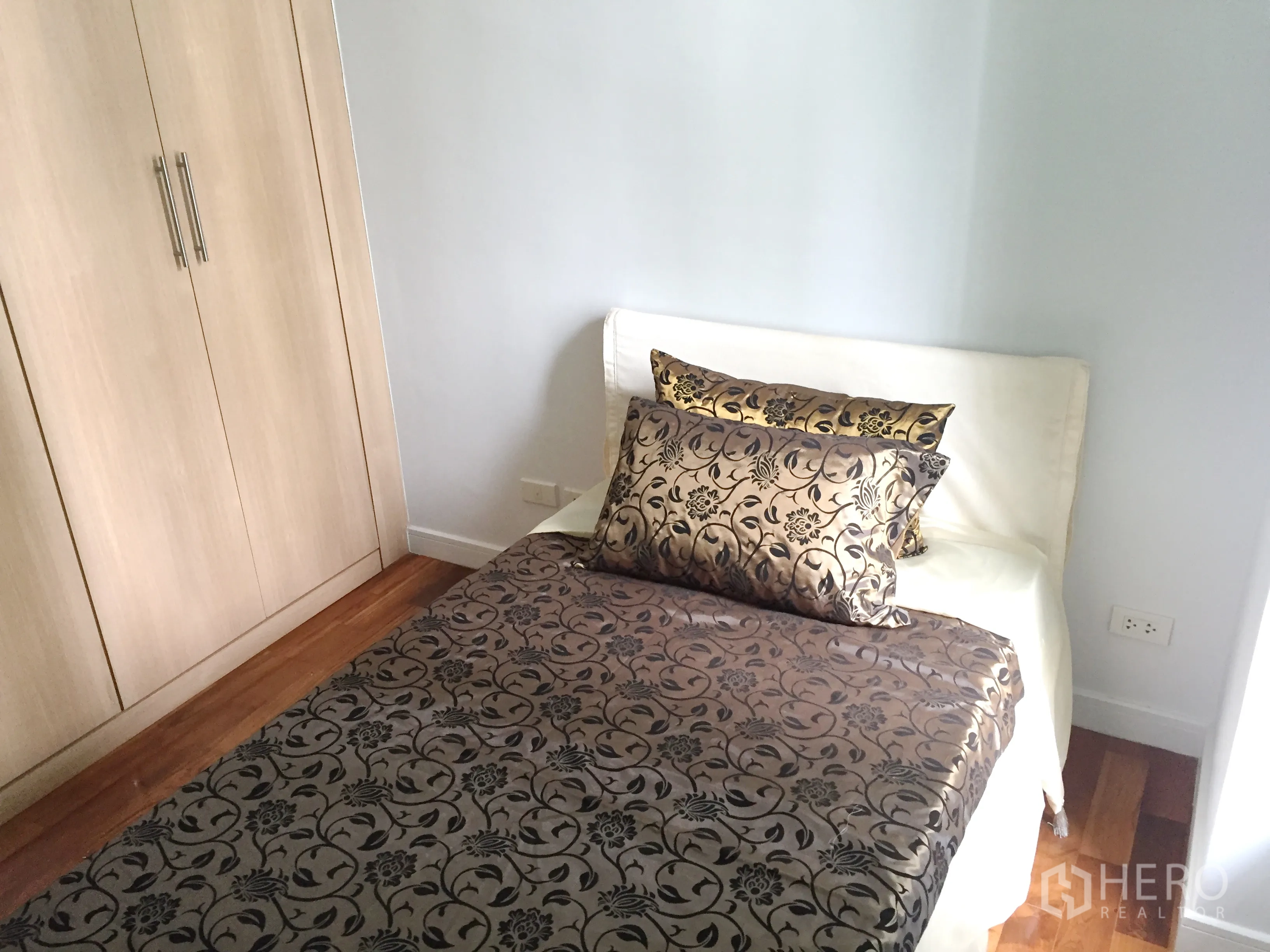公寓 出租在Khlong Toei, Bangkok - 温馨单人卧室，配嵌入式衣柜与木地板。