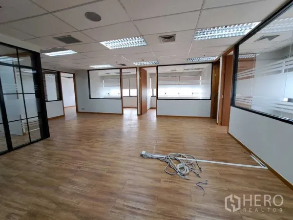 Office Space for rent in Bang Rak, Bangkok - Large office floor with multiple glass‑partitioned rooms and fluorescent ceiling lights.