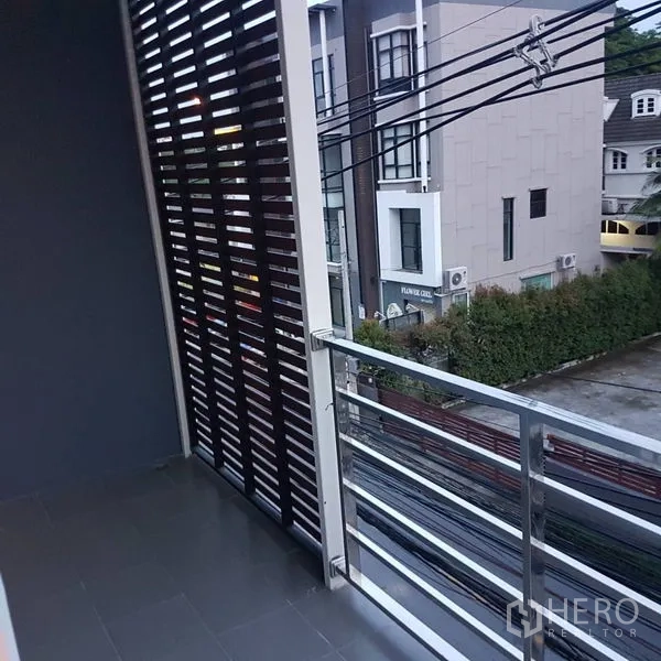 Home Office for sale in Lat Phrao, Bangkok - Shaded balcony with metal railing and privacy screen overlooking the street.