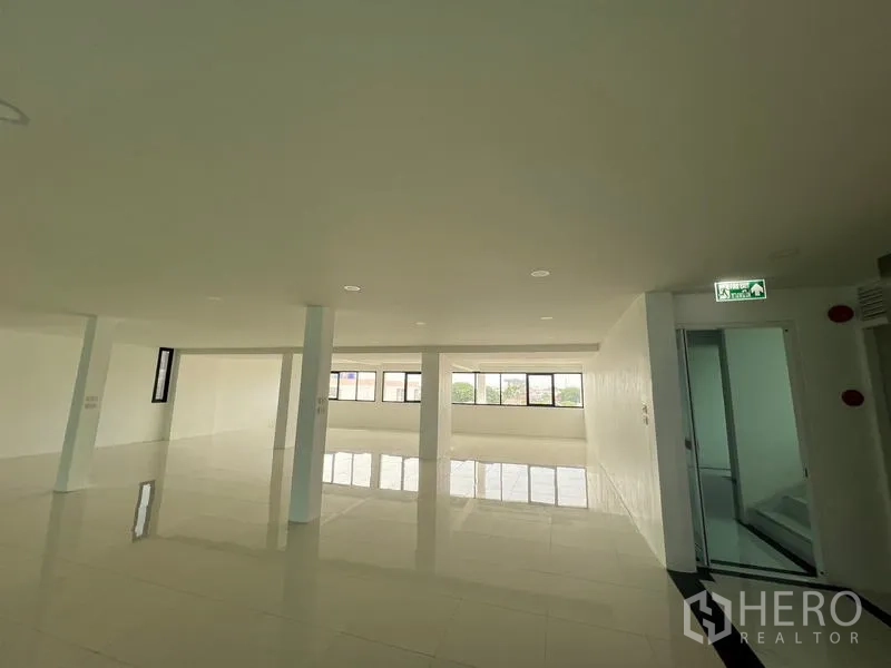 Office Space for rent or sale in Wang Thonglang, Bangkok - Office corridor and open area with exit sign and windows.
