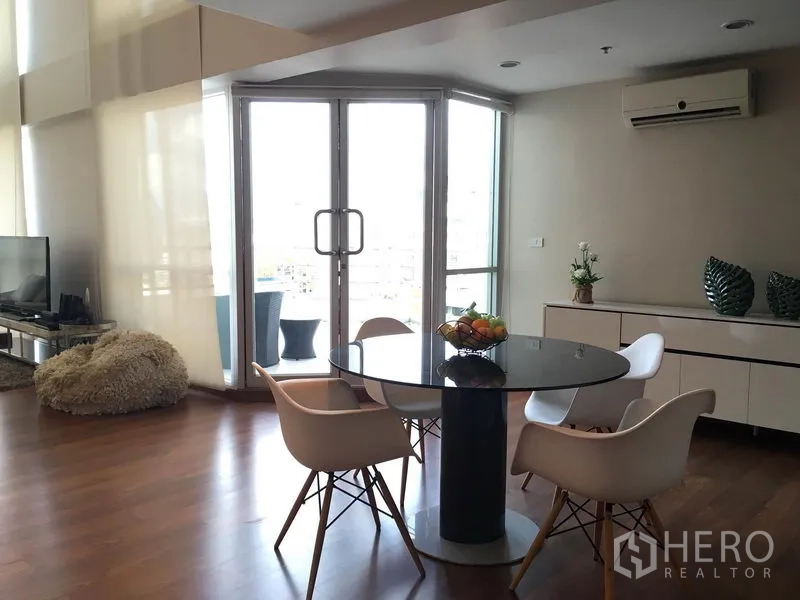 公寓 出租在Pathum Wan, Bangkok - 阳台旁的用餐区，城市景观与白色边柜