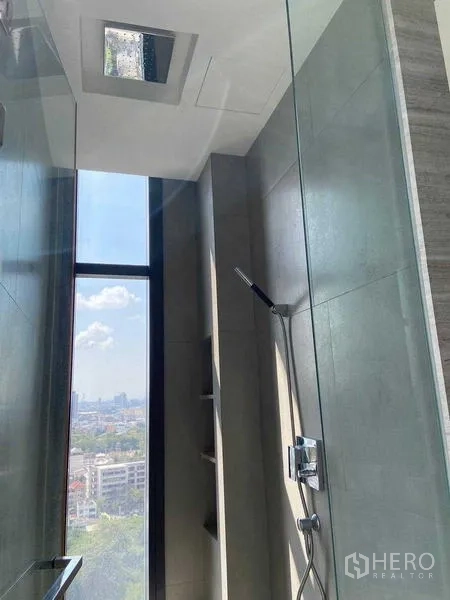 公寓 出售在Bang Rak, Bangkok - 玻璃淋浴间，手持花洒与高窗引入城市光线。