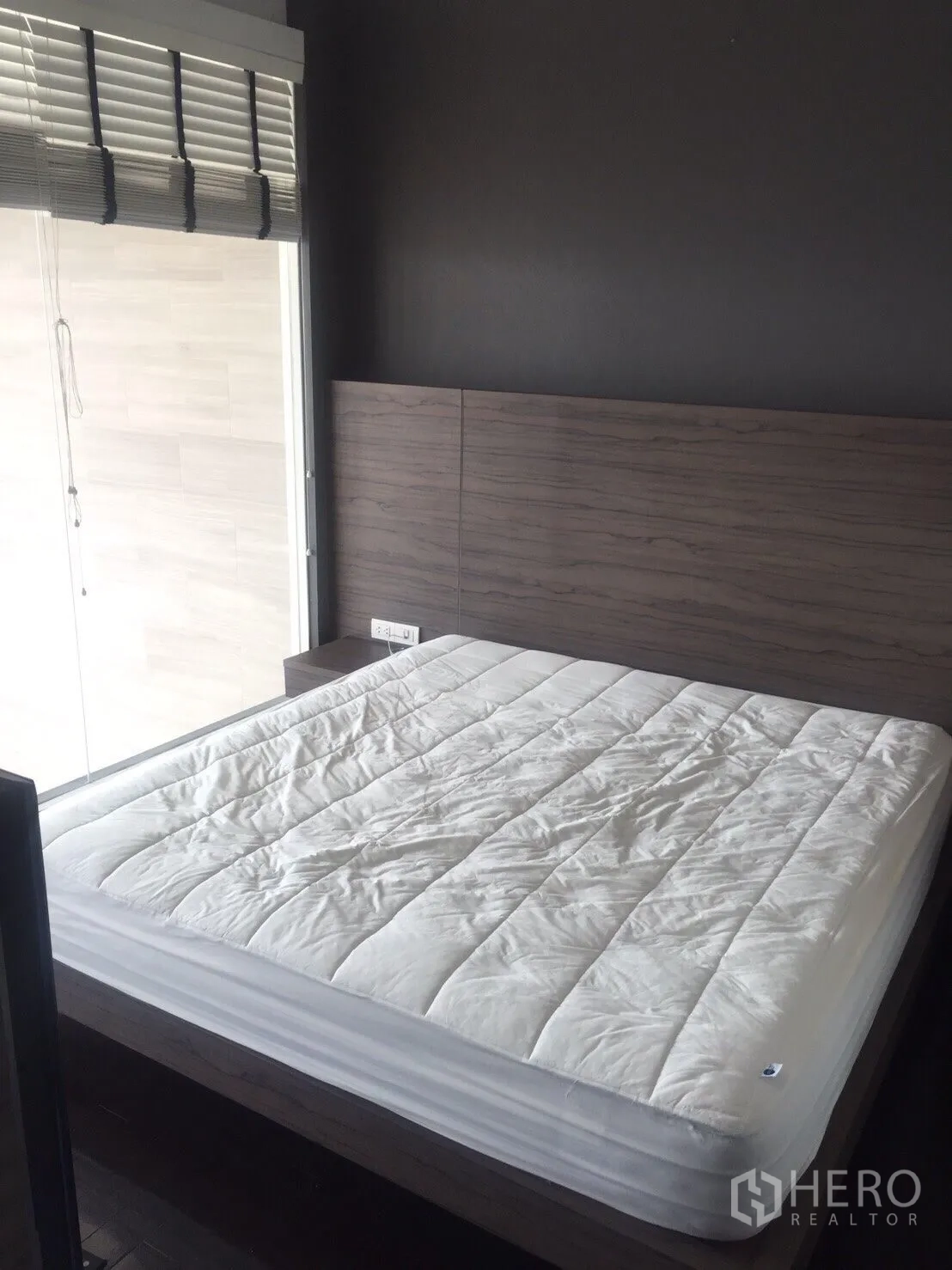 公寓 出租在Khlong Toei, Bangkok - 舒适卧室配大床、木质床头板与百叶窗。
