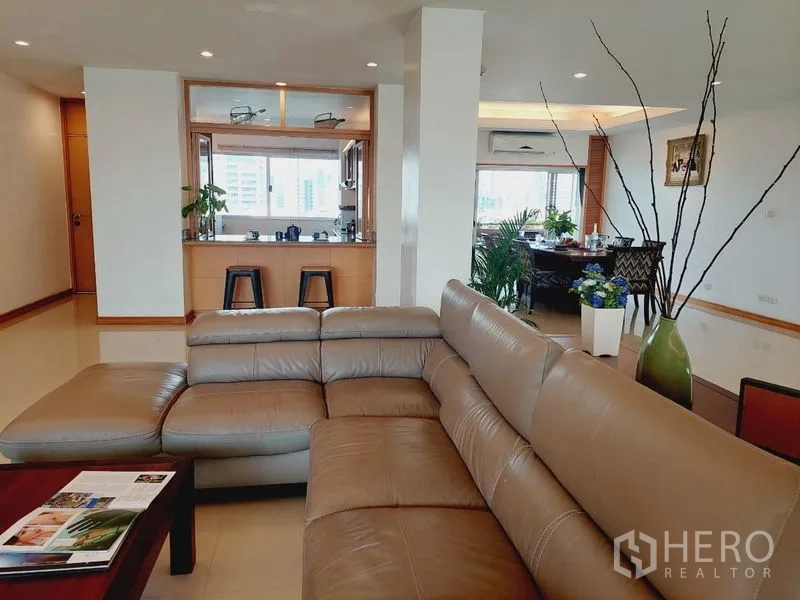 Apartment for rent - Open-plan lounge with leather sectional sofa facing the kitchen pass-through.