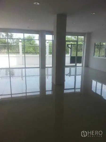 Factory for rent in Khlong Luang, Pathum Thani - Bright tiled office or showroom with large windows and gated frontage outside.