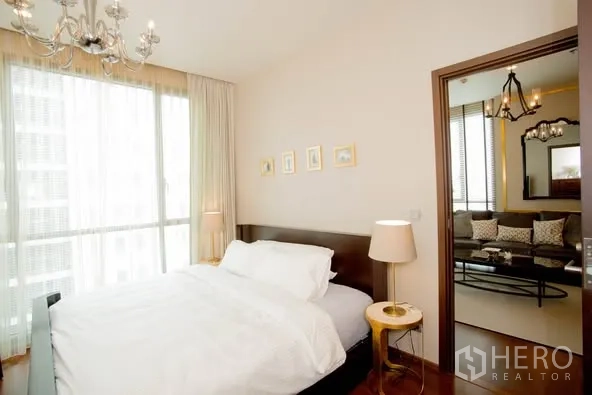 คอนโด ให้เช่าในWatthana, Bangkok - ห้องนอนอบอุ่น ผ้าปูเตียงสีขาว โคมไฟหัวเตียง ผ้าม่านโปร่ง มองเห็นห้องนั่งเล่น