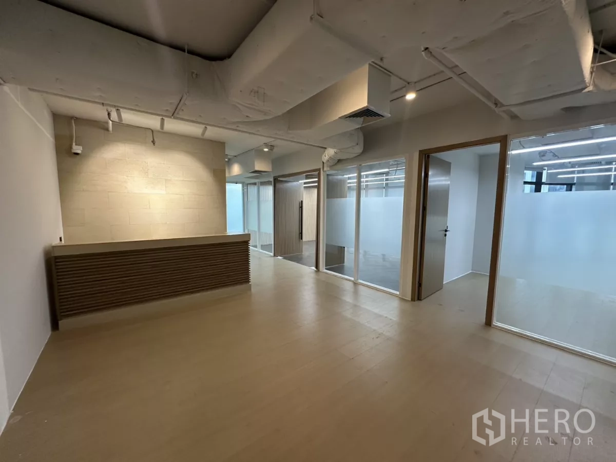 办公空间 出租在Watthana, Bangkok - 接待大堂，内建柜台与相邻玻璃办公室。