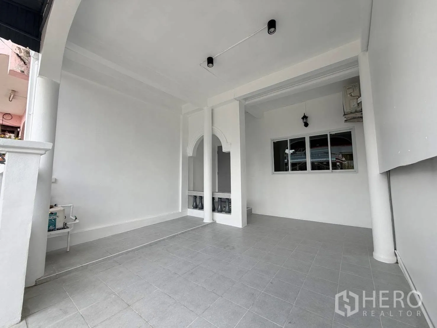 ทาวน์เฮาส์ for rent in Phra Khanong, Bangkok - ลานจอดรถหน้าบ้านแบบมีหลังคา ปูกระเบื้อง พร้อมเสาโค้งและหน้าต่าง.