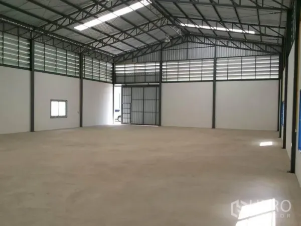 货栈 出租在Lam Luk Ka, Pathum Thani - 375㎡仓库内部，高钢架屋顶、通风百叶及大型滑动进出门。