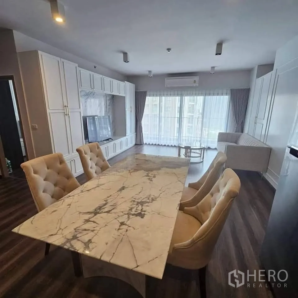 คอนโด for rent in Huai Khwang, Bangkok - มุมรับประทานอาหารโต๊ะหินอ่อน เก้าอี้บุนวม หันหน้าไปยังผนังทีวีและหน้าต่างสูง