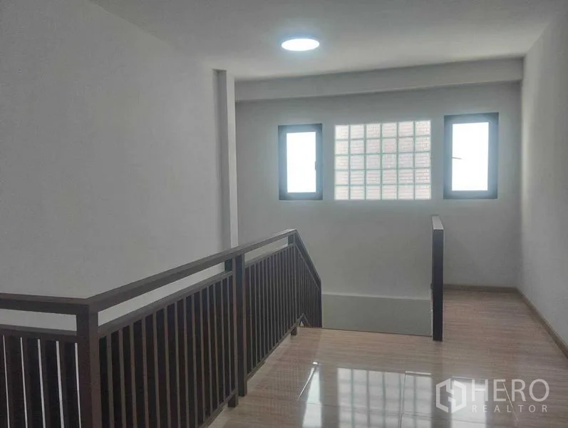 Detached House for sale in Phra Khanong, Bangkok - Stairwell landing with windows and glass-block panel bringing natural light.