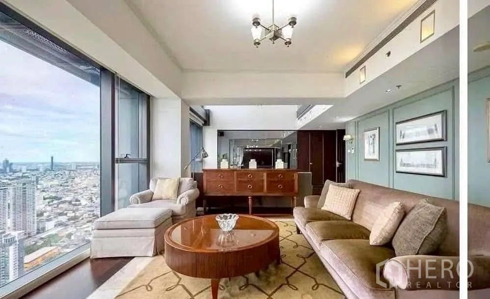 公寓 出租在Sathon, Bangkok - 舒适会客角，沙发与扶手椅配边柜，框景大窗俯瞰城市。